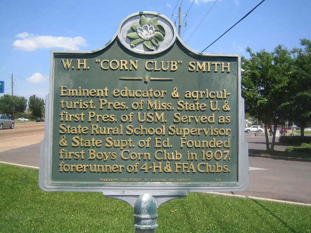 This marker for "Corn Club" Smith is on Highway 12 near the intersection with Louisville Street in Starkville.